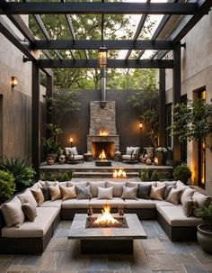 an outdoor living area with couches, tables and fire pit in the middle of it