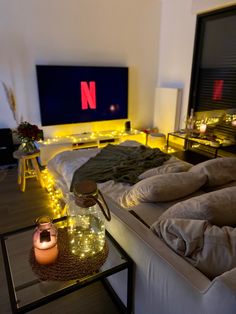 a bedroom with lights on the floor and a television in the background