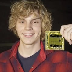 a young man holding up a gold bar with the word maquinn on it