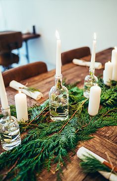 the table is set with candles and greenery