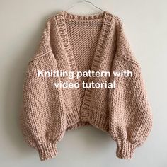 a knitted sweater hanging on a hanger with the text knitting pattern with video tutorial