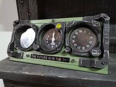 three gauges sitting on top of a wooden table