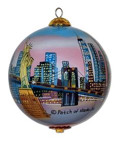 a glass ornament with the statue of liberty and new york city in the background