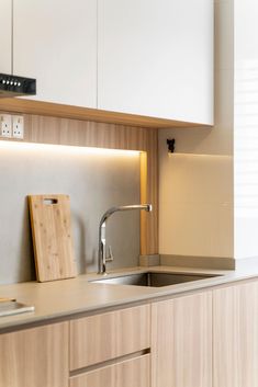 a kitchen with white cabinets and wooden counter tops is pictured in this image, there are two cutting boards on the counter