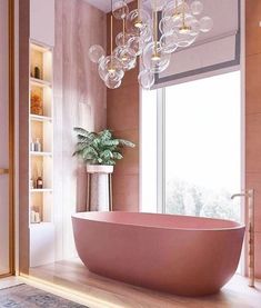 a bathroom with a pink bathtub and chandelier hanging from it's ceiling