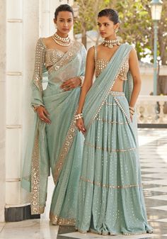 Introducing the ethereal powder blue tiered saree with a glam sleeveless blouse. This stunning saree features delicate powder blue georgette adorned with real hand-cut mirror embroidery. The multi-tier design adds volume and movement, creating a mesmerizing silhouette. Paired with a stylish, modern cut sleeveless blouse embellished with hand-cut mirrors, this set exudes glamour. Ideal for Mehendi or Sangeet ceremonies. Composition : Saree & Blouse - Georgette Care: Dry Clean Only and Vacuum Storage This product can be customized for sleeves, length and colour Delivery : 6-8 weeks as the product is hand crafted. Check Size Guide or choose MySize for free customisation (All Sizes above XL can be made at 15% additional cost) For more information and sizes please contact fabiliciousfashion@gma Saree With Sleeveless Blouse, Tiered Lehenga, Mirror Blouse, Sky Blue Saree, Vani Vats, Sequins Saree, Mirror Embroidery, Blue Organza, Organza Lehenga