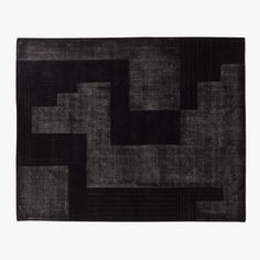 a black and grey rug on a white background with an abstract design in the middle