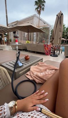 a woman laying on top of a table next to an umbrella