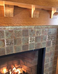 a fireplace that has some kind of tile on it and is lit by the fire