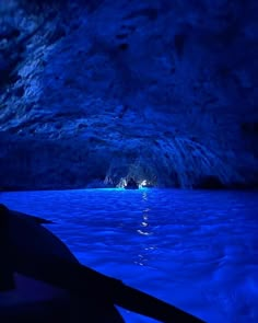 the inside of a cave with blue water