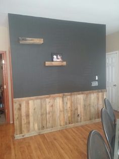 an empty room with wooden floors and black walls