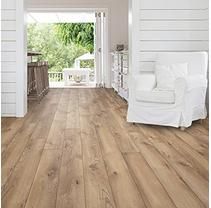 a living room with white furniture and wood flooring on the walls, along with an open door leading to a porch