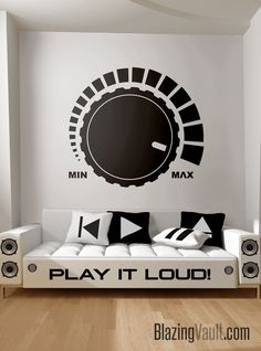 a couch sitting in front of a wall with a play it loud sign on it