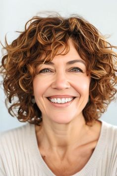 Auburn curls are perfectly sculpted to frame the face with warmth and vibrancy. The lively spirals are a quick and easy wash and wear hairstyle. Click here to see more stunning curly hairstyles for women over 50. Curly Hairstyles For Older Women Over 50 With Bangs, Short Wavy Hairstyles For Women Over 50, Short Wavy Hair Bangs, Curly Bobs For Older Women, Shirt Curly Hairstyles, Auburn Curls, Short Wavy Hairstyles For Women, Long Natural Curls, Hair Pic