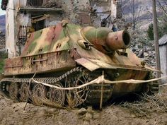 an old tank sitting on the ground in front of a building that has been torn down