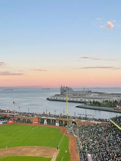 an aerial view of a baseball field with the ocean in the background