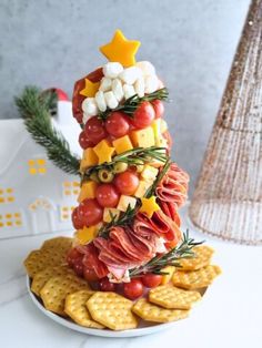 a christmas tree made out of crackers on a plate with cheese and meats