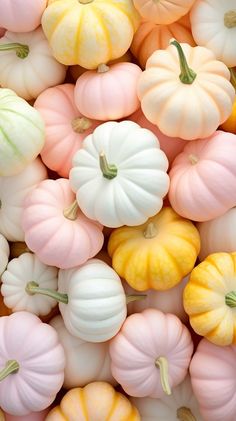 many different colored pumpkins are stacked together