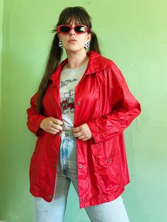 "+ comfy, casual, & colorful vintage eighties windbreaker jacket in an ultra bright & bold shade of red + relaxed, sporty shape with long sleeves, open shoulders, collared neckline, & brass snap front closure (with more snap closures at each pocket & sleeves cuff) + two front pockets at each hip & a small zipper pocket at the right chest + small stretchy elastic insert at the center back of jacket to aid in fit  + 100% nylon ~ feels like the classic lightweight, swishy material with a bit of ref Trendy Oversized Red Outerwear, 90s Spring Outerwear With Relaxed Fit, 90s Style Relaxed Fit Spring Outerwear, Trendy Red Collared Outerwear, Red Relaxed Fit Outerwear For Streetwear, 90s Style Long Sleeve Spring Outerwear, Red Summer Outerwear With Pockets, Trendy Red Windbreaker For Streetwear, Vintage Oversized Outerwear For Summer