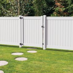 a white fence with stepping stones in the grass