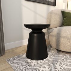 a black stool sitting on top of a wooden floor next to a white chair in a living room