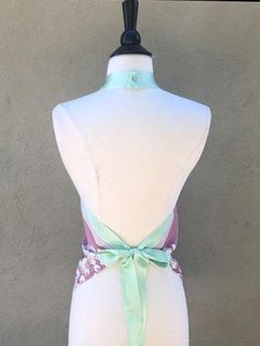 Created from upcycled scarf fabrics, each halter top in this collection is one of a kind. A simple triangle top with a retro vibe, this halter top is fastened at the back neck with a button closure and tied at the back waist with a double faced satin ribbon.Ribbon can also be tied in front for a waist accent. An easy feminine top to wear on hot summer days. Vegan Chic Tie Back Halter Top For Festivals, Chic Festival Halter Top With Tie Back, Summer Satin Halter Top With Tie Back, Festival Triangle Top Halter With Tie Back, Festival Triangle Halter Top With Tie Back, Festival Halter Top With Tie Back Triangle Shape, Summer Fitted Halter Top With Bow Tie Back, Fitted Summer Halter Top With Bow Tie Back, Fitted Halter Top With Bow Tie Back For Summer