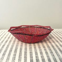 a red bowl sitting on top of a white and black tablecloth covered table cloth