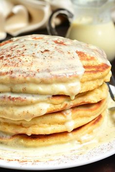 a stack of pancakes covered in white sauce