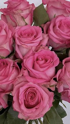 a vase filled with pink roses on top of a table