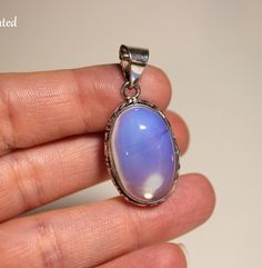 Step into the realm of celestial beauty with this enchanting Opalite gemstone pendant, delicately embraced by a sterling silver setting. Each facet of the Opalite captures the essence of the cosmos, radiating a luminous glow that mesmerizes the beholder and stirs the soul. --Setting including bail measures 38x18x8.5mm  --.925 Sterling Silver plated over copper setting, real gemstone Imagine a Opalite gemstone, shimmering with iridescent hues of blue, purple, and milky white. Nestled within a sterling silver setting, the Opalite seems to hold the secrets of the universe within its ethereal depths. As light dances across its surface, it creates a mesmerizing display of color and light, evoking the enchanting beauty of distant galaxies. Elevate your spiritual journey and adorn yourself with t Secrets Of The Universe, Semi Precious Gems, Black Gift Boxes, White Crystal, Precious Gems, Pendant Set, Crystal Pendant, Gemstone Pendant, Cosmos