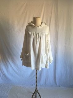 "vintage 1970s pullover hooded shirt label- Old Town white cotton gauze long sleeve, pleated  2 front pockets good vintage condition, has some wear/thread pulls/stains throughout,  fits like one size fits most,  measures, lying flat, neck to sleeve-23 1/2\" chest-22 1/2\" hem-28 1/2\" length-26\"" Vintage Long Sleeve Top With Drawstring Hood, Vintage Hooded Top With Relaxed Fit, Vintage Long Sleeve Hoodie For Spring, White Smock Long Sleeve Tops, Spring Vintage Hoodie With Relaxed Fit, Vintage Relaxed Fit Hoodie For Spring, Vintage White Long Sleeve Hoodie, Cream Relaxed Fit Hooded Tops, Cream Hooded Tops With Relaxed Fit