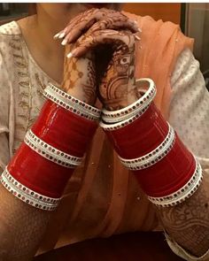 a woman holding her hands to her face with hendi tattoos on their arms and legs