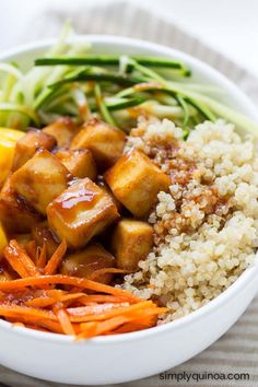 a white bowl filled with rice, carrots and tofu