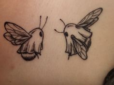 two small tattoos on the back of a woman's stomach, one with a hummingbird and the other with a bee