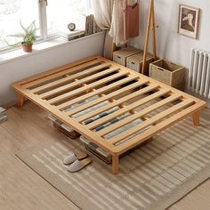 a wooden bed frame sitting on top of a rug next to a radiator