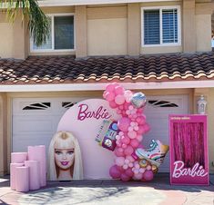 there is a barbie doll and balloons in front of a house with a barbie sign