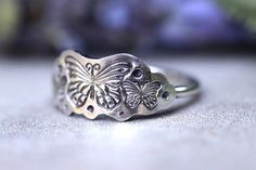 This listing is for one unique, fun, and feminine sterling silver butterfly stacking ring. It features three beautiful and detailed hand-stamped butterflies in a crown arrangement. This ring is perfect for all butterfly lovers and gardeners and makes a great spring and summer ring!It looks great solo or stacked with other rings and bands.- Choose your size at check-out!- Butterfly stamping measures 20mm by 9mm- Ring band is 1.5 mm tall.Want to stack it with some awesome textured silver stacking Silver Butterfly Ring, Rings And Bands, Silver Crown Ring, Jeweled Bag, Summer Rings, Bee Ring, Sterling Silver Stacking Rings, Nature Ring, Silver Crown