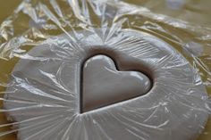 a cookie shaped like a heart in plastic wrap