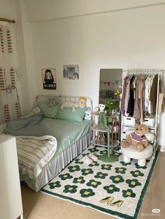 a bed room with a neatly made bed and a teddy bear sitting on the floor