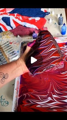 someone is painting with red and white paint