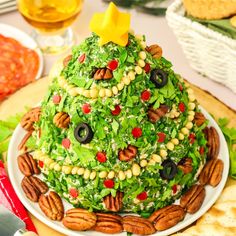 a christmas tree made out of lettuce and nuts on a plate with crackers