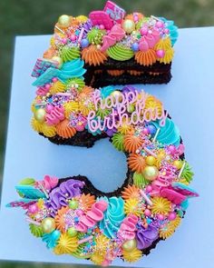 a birthday cake that is shaped to look like the number five with flowers and candles