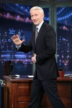 a man in a suit and tie is walking on the set of late show with jimmy stewart