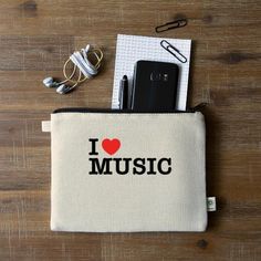 i love music pouch with phone, headphones and earbuds on the table