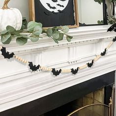 a mantle decorated with halloween decorations and greenery