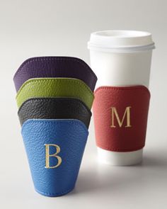 three different colored leather cups with the letter m on one cup and the word b on the other