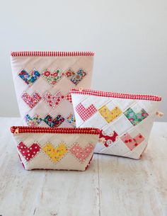 three small purses sitting on top of a white wooden table next to each other