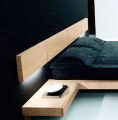 a bed that is sitting in the middle of a room next to a night stand