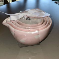 a stack of pink bowls with white bows on them sitting on top of a table