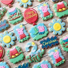 some peppa pig cookies are arranged on a wooden table with the words happy birthday